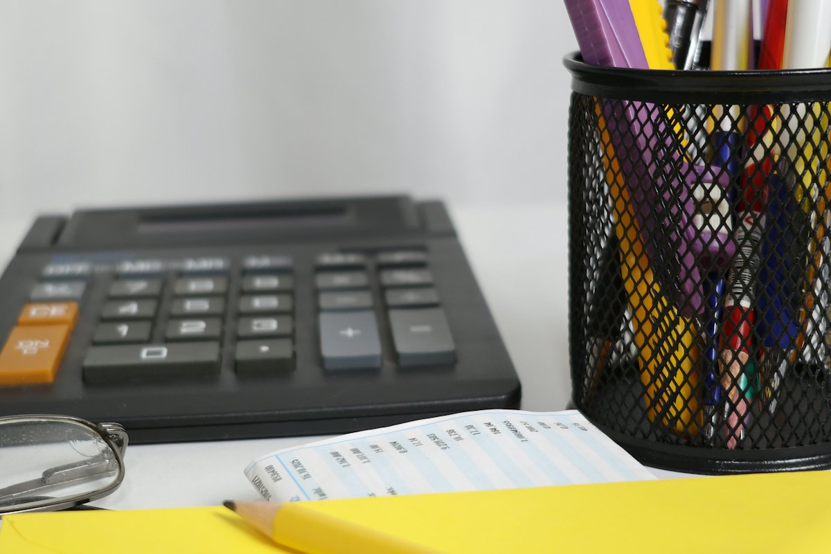 A calculator and notepad on a desk