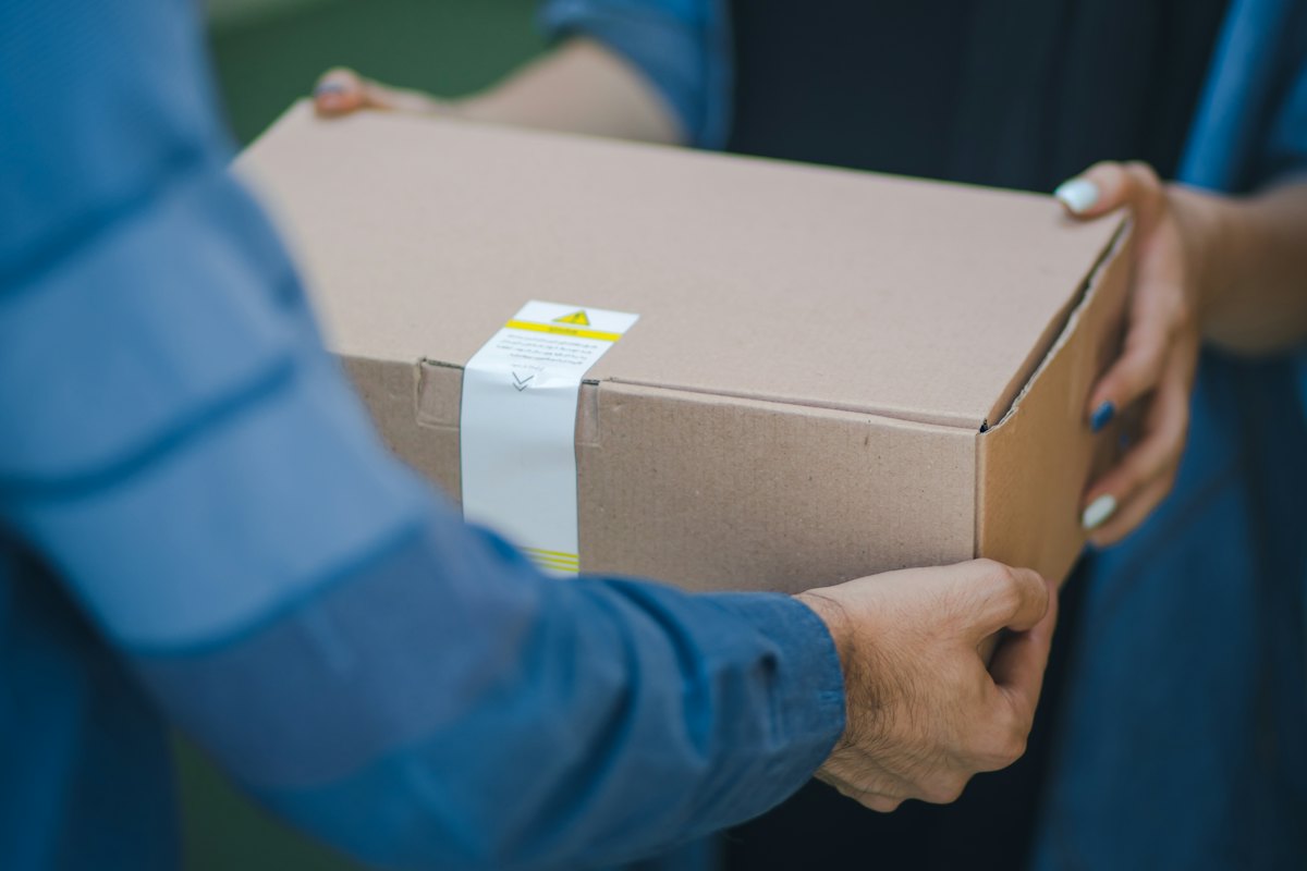A courier handing a parcel to a customer